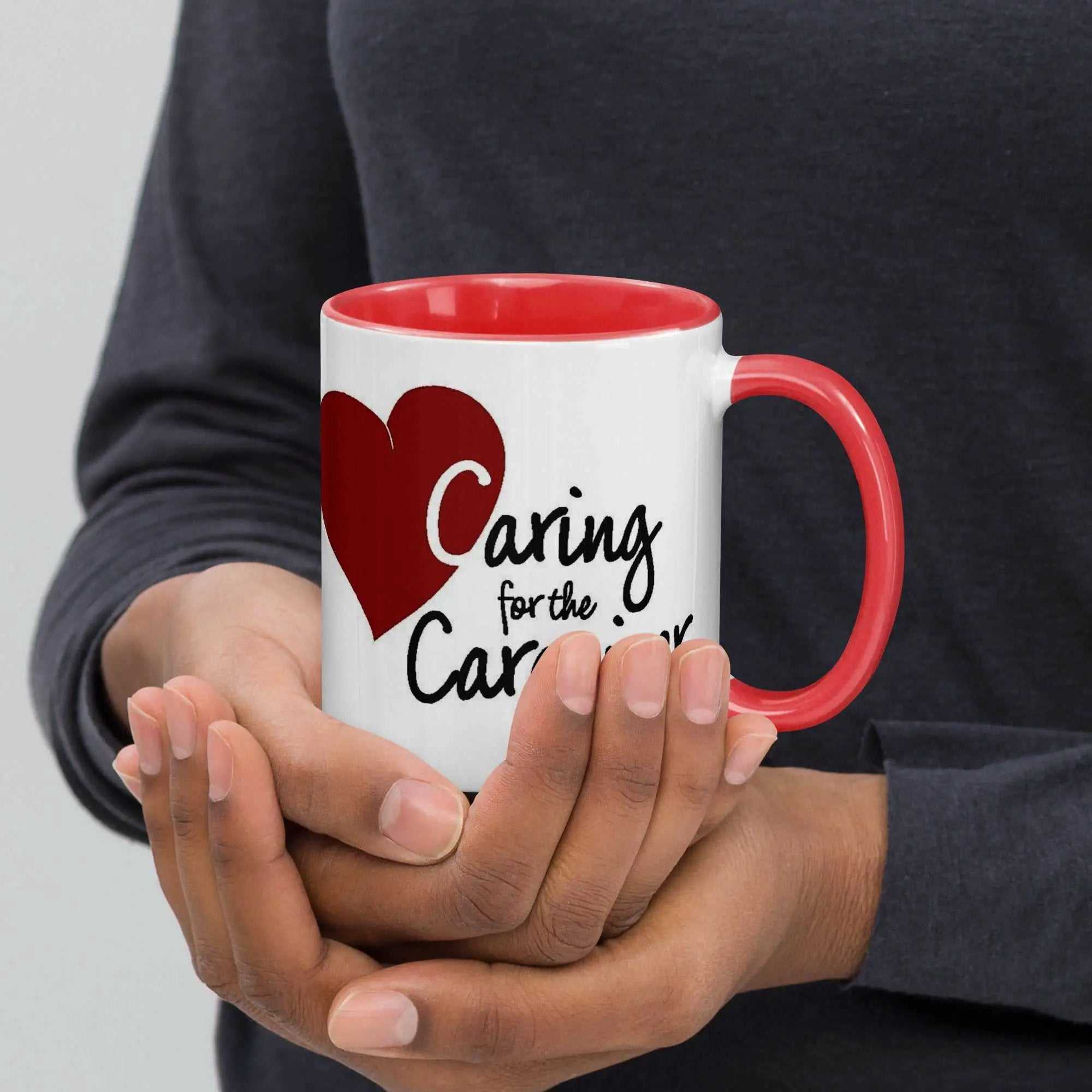 Caring for the Caregiver ceramic mug with red interior and handle held in hands