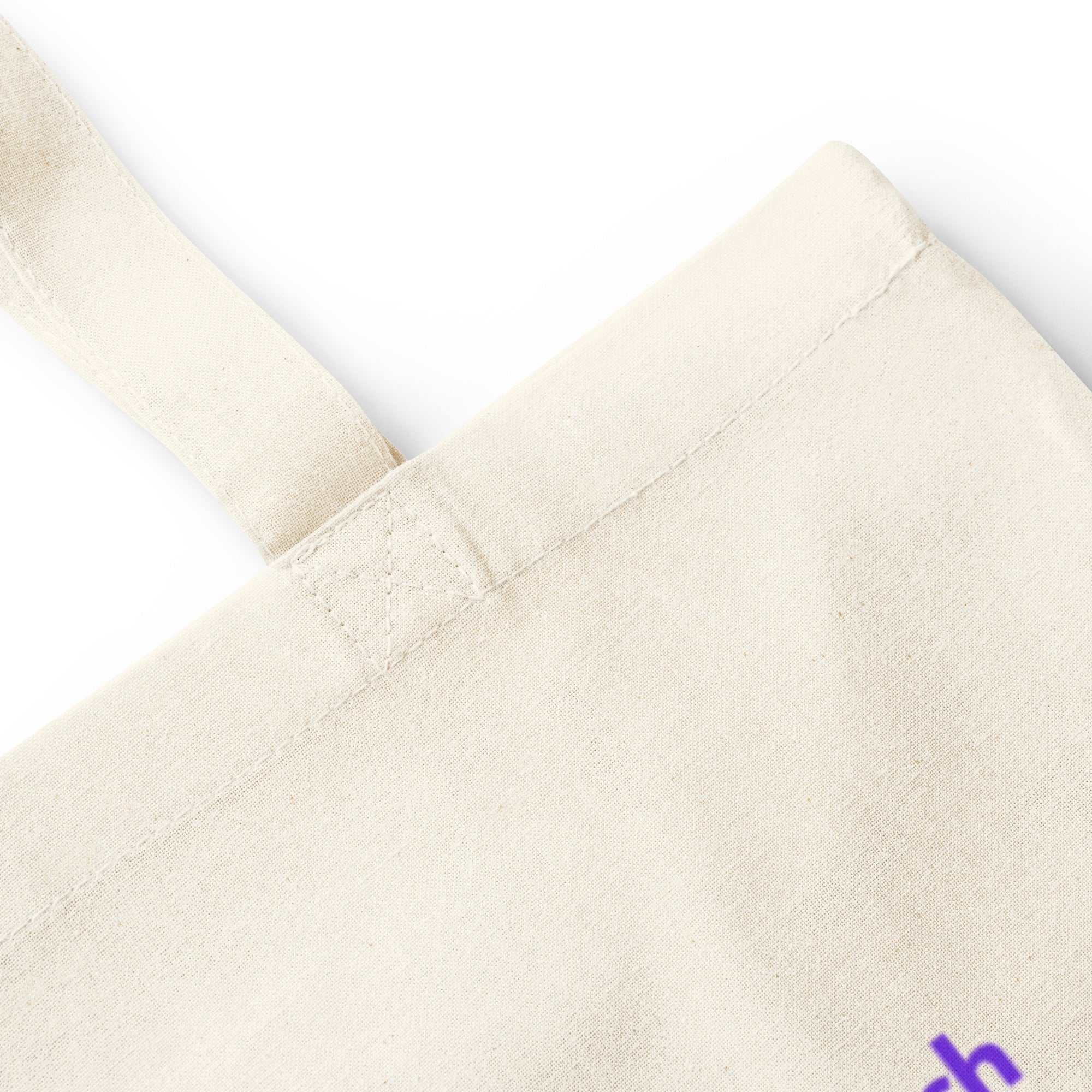 Close up of the handle and top corner of a natural cotton tote bag