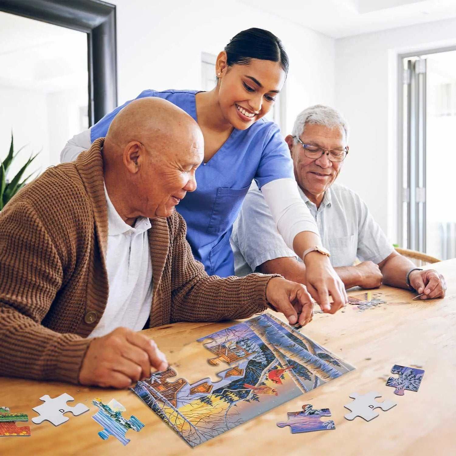 Caregiver and two seniors assembling a large piece puzzle on a wooden table