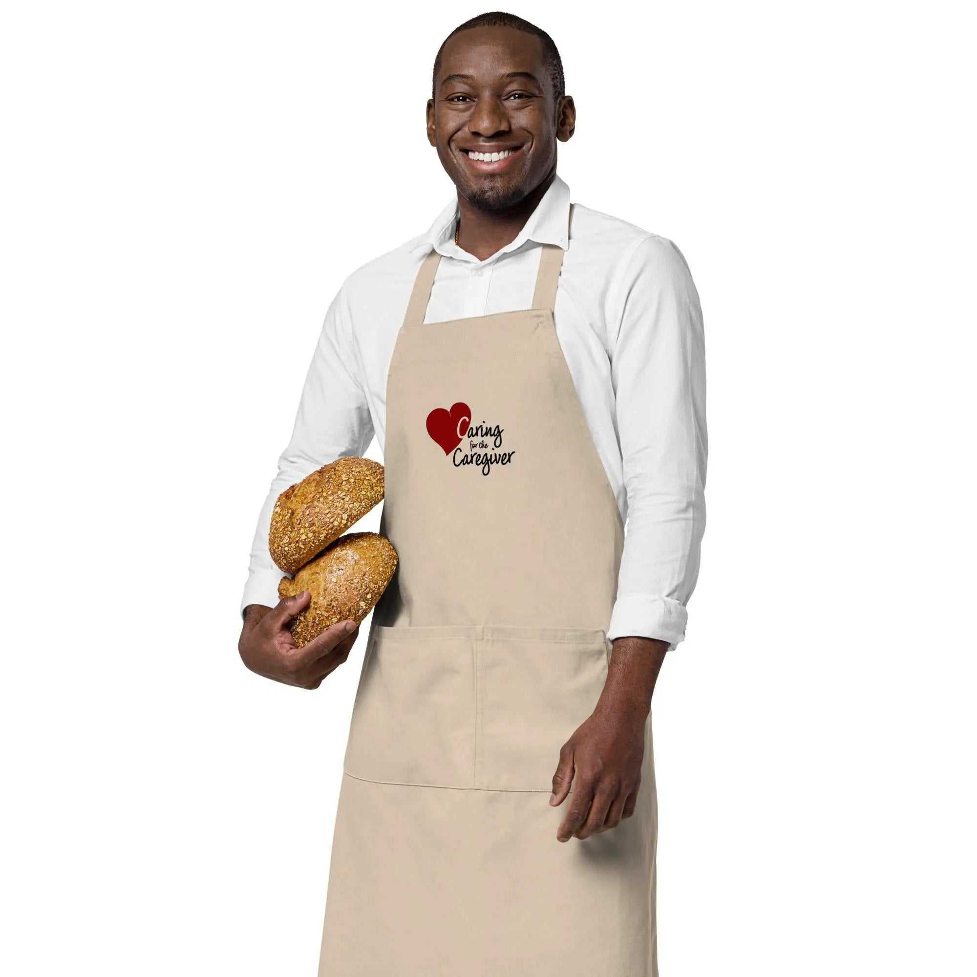 Man wearing a beige Caregiver Apron holding two loaves of bread