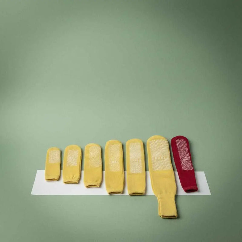 Yellow medium patient slipper socks from Rifz Textiles Inc, designed for comfort and stability in healthcare settings.