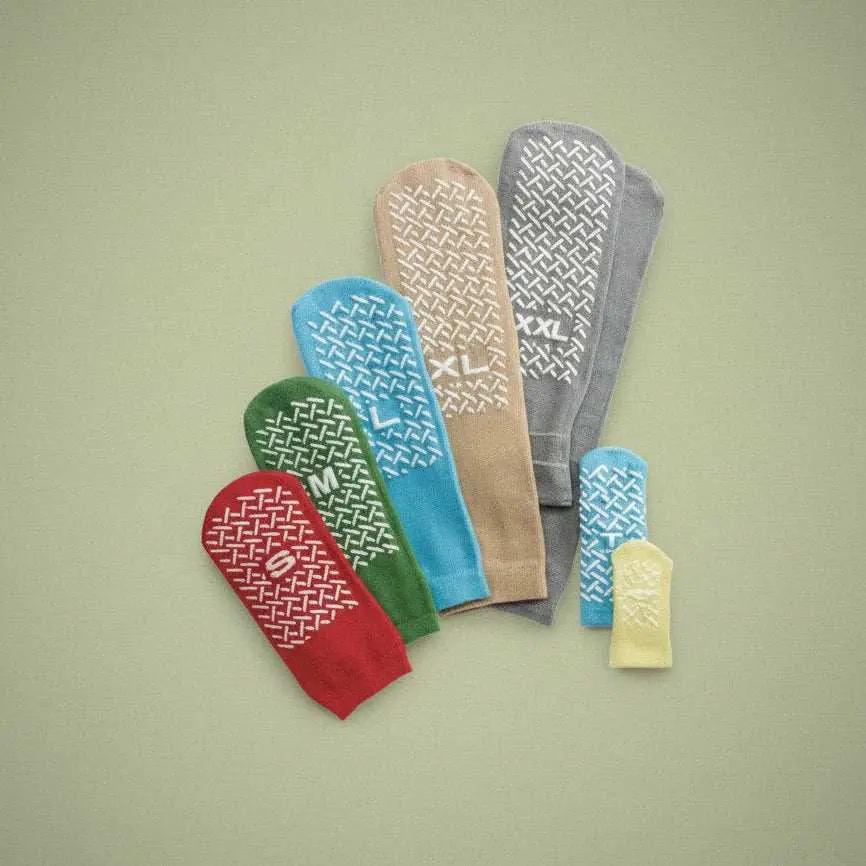 Red healthcare patient slipper sock with non-slip tread, small size, designed for comfort and stability in care settings.