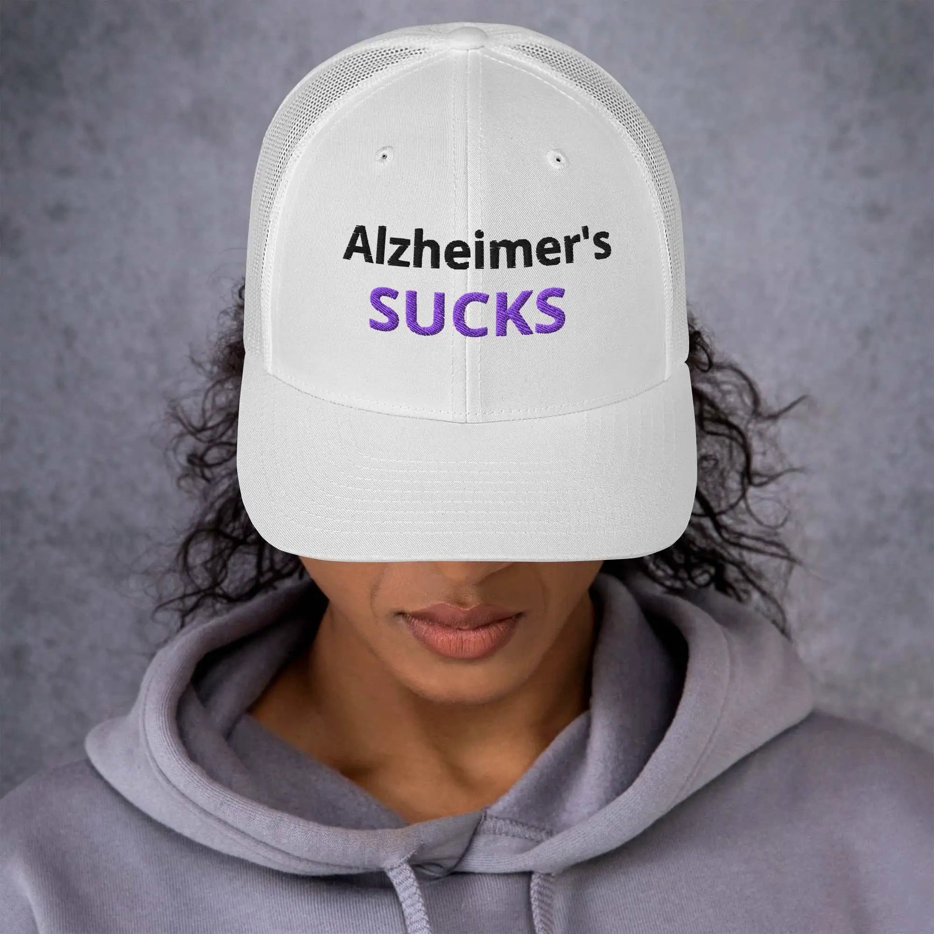 White embroidered Alzheimer's awareness trucker cap with retro design, featuring supportive message on the front.