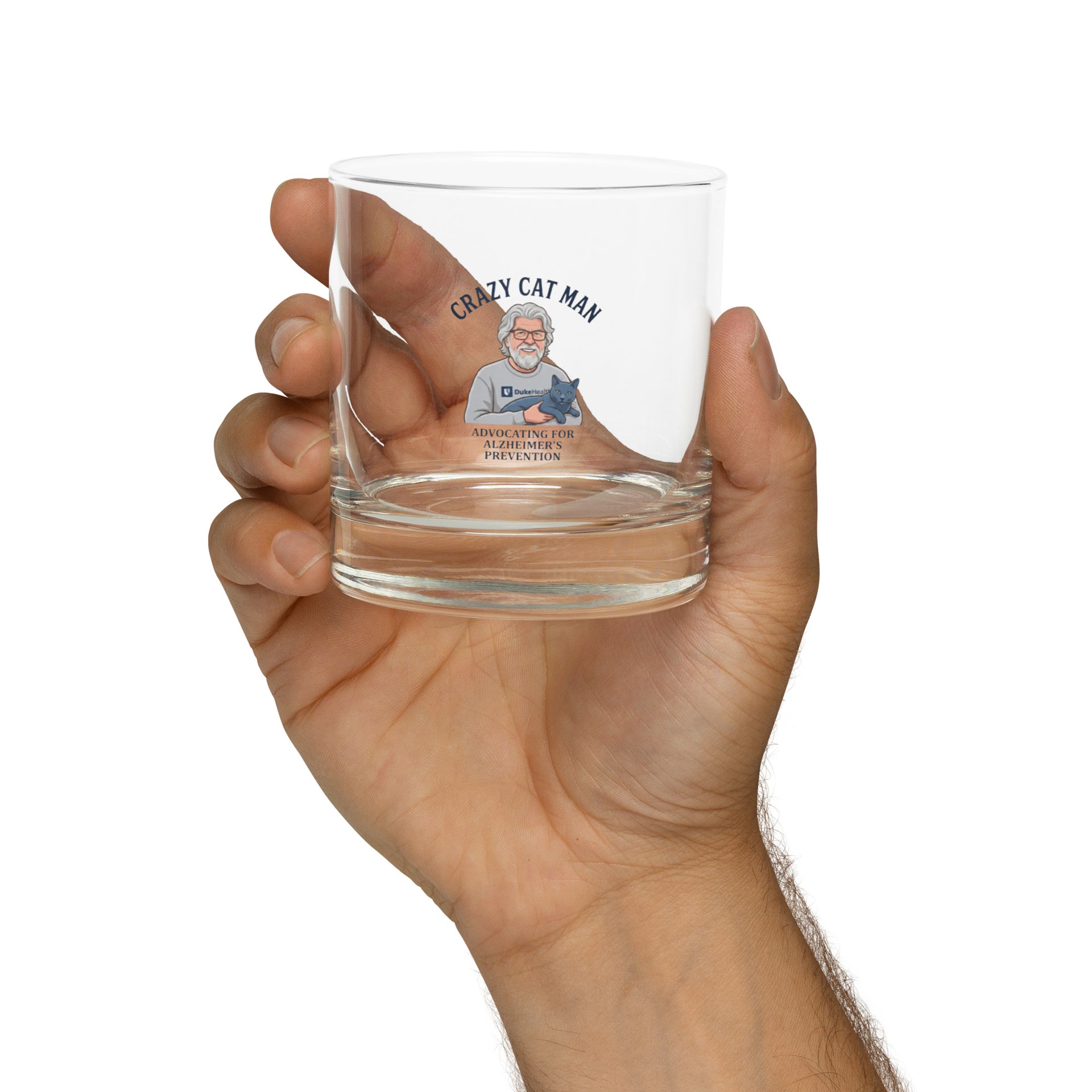Hand holding The Cat Man signature rocks glass with Alzheimer prevention graphic