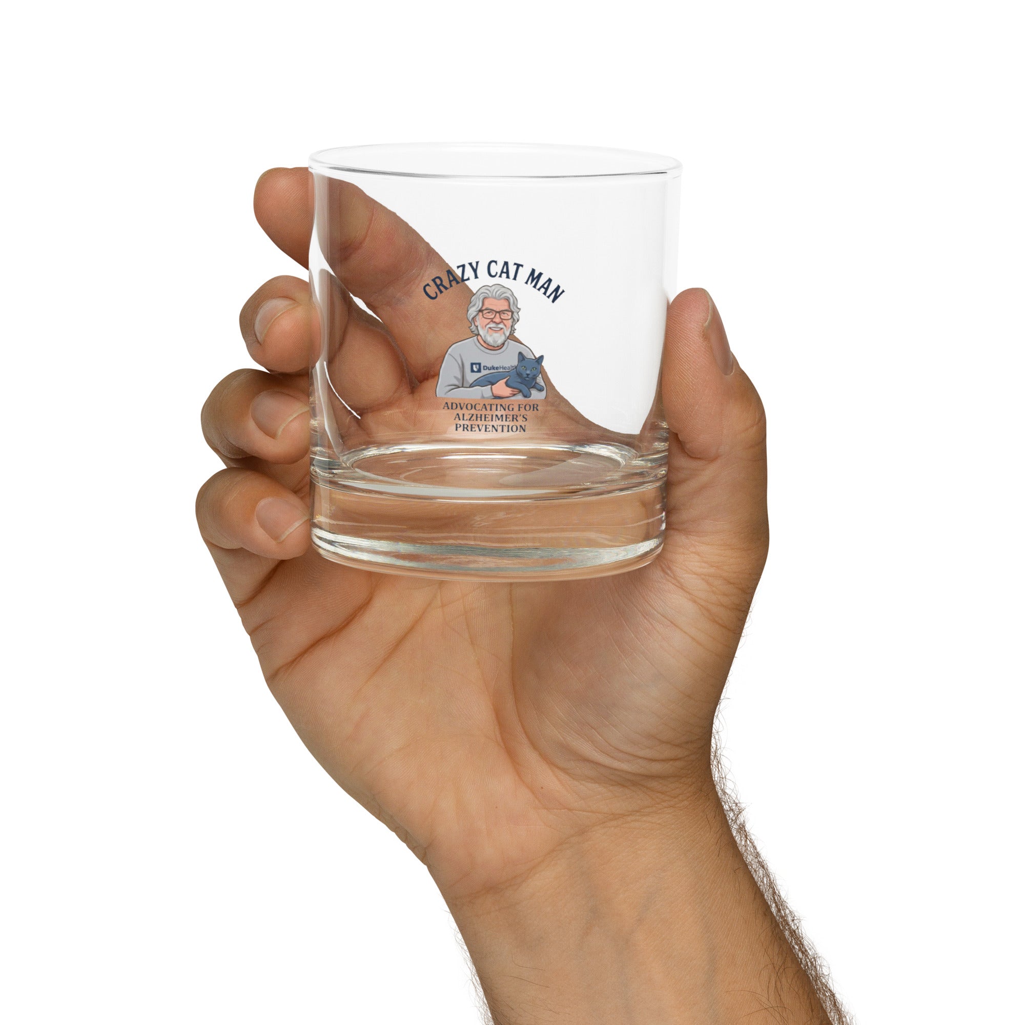 Hand holding The Cat Man signature rocks glass with Alzheimer prevention graphic