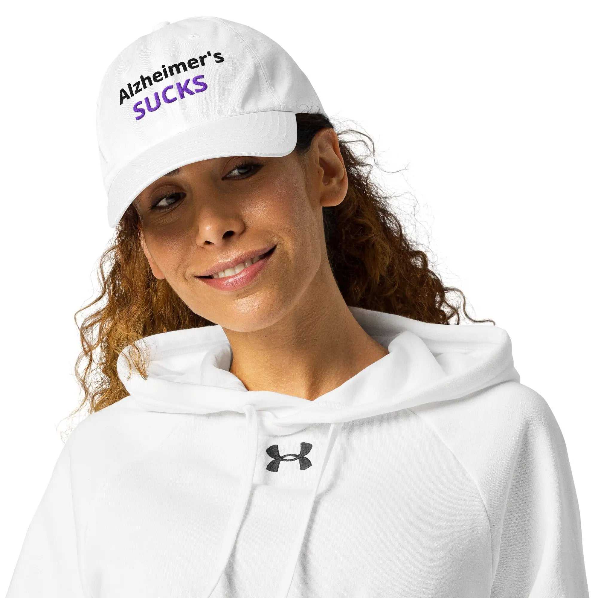 Person wearing a white Under Armour dad hat embroidered with Alzheimer's SUCKS