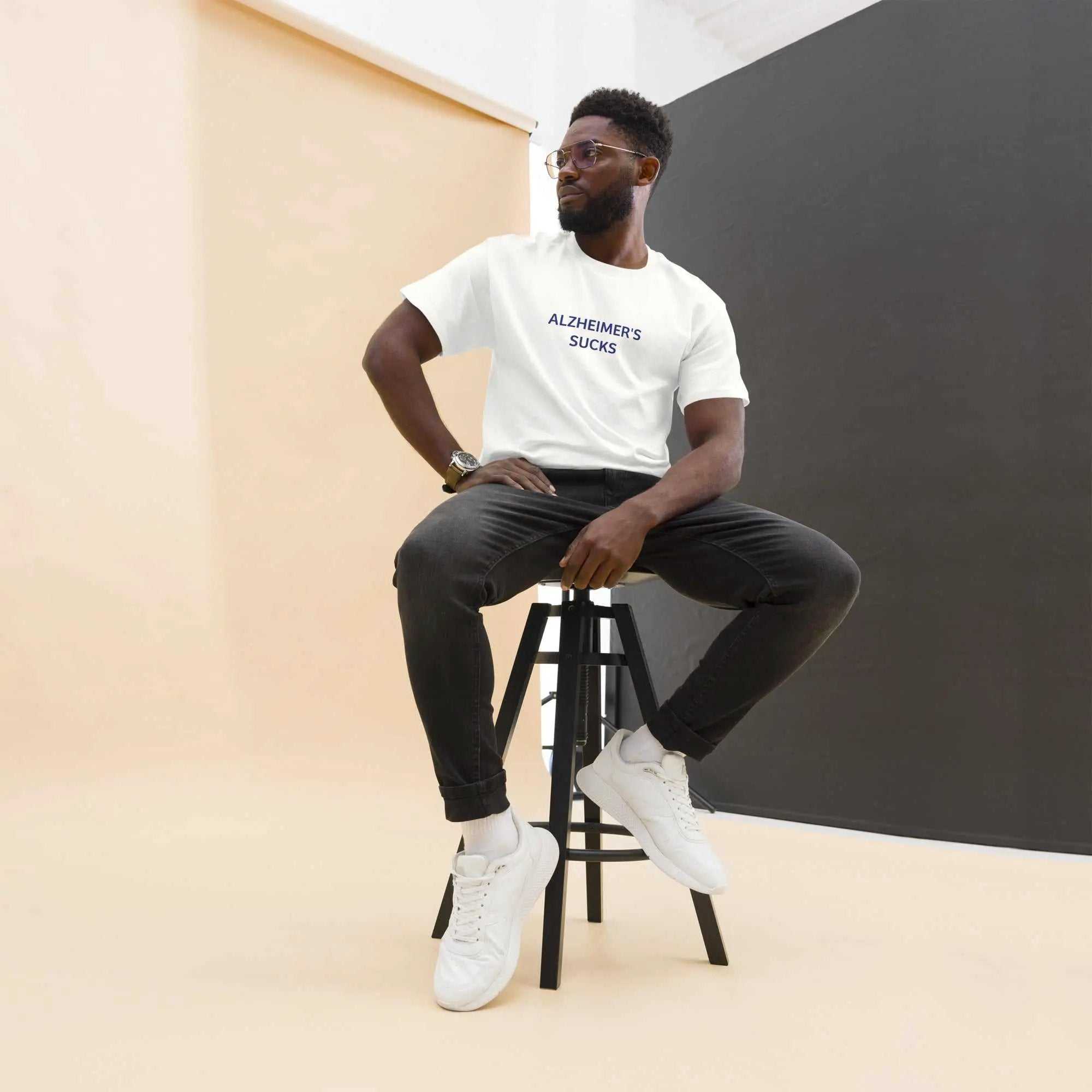 Man wearing a white Alzheimers Sucks t-shirt sitting on a stool