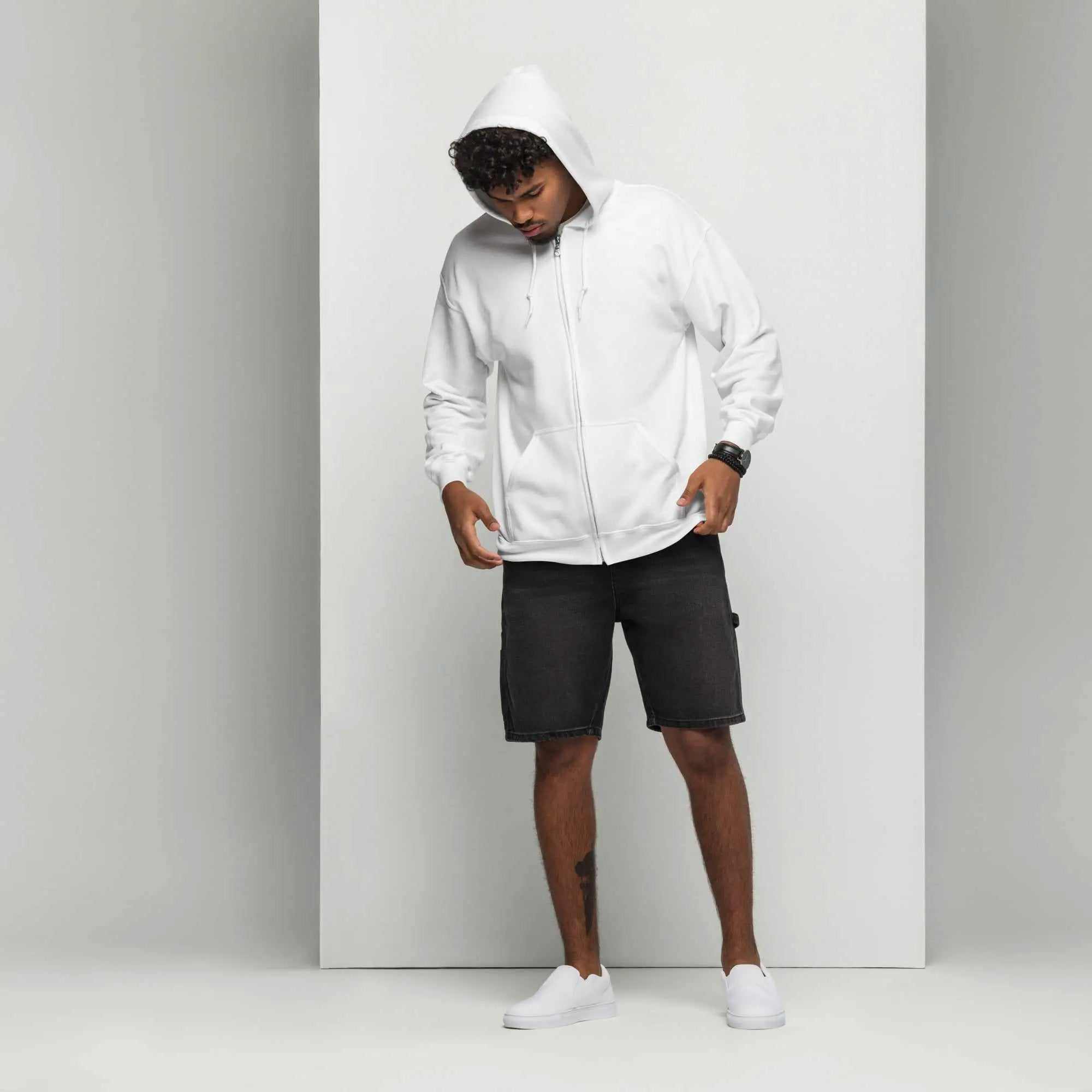 Man wearing a white Unisex Heavy Blend Zip Hoodie with black shorts and white sneakers