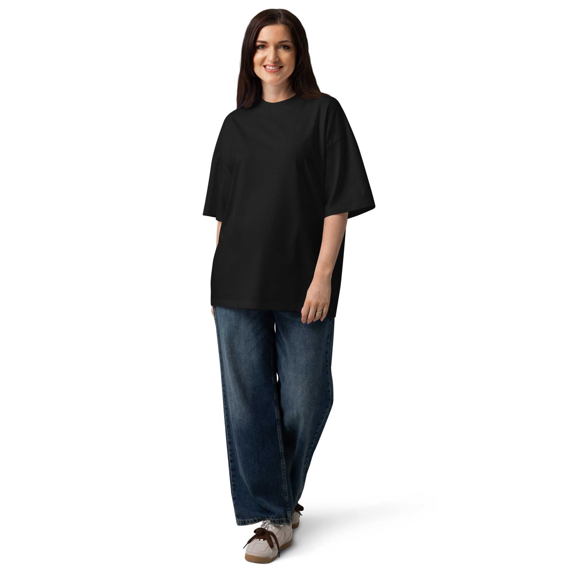 Person wearing a black unisex organic oversized t-shirt with blue jeans