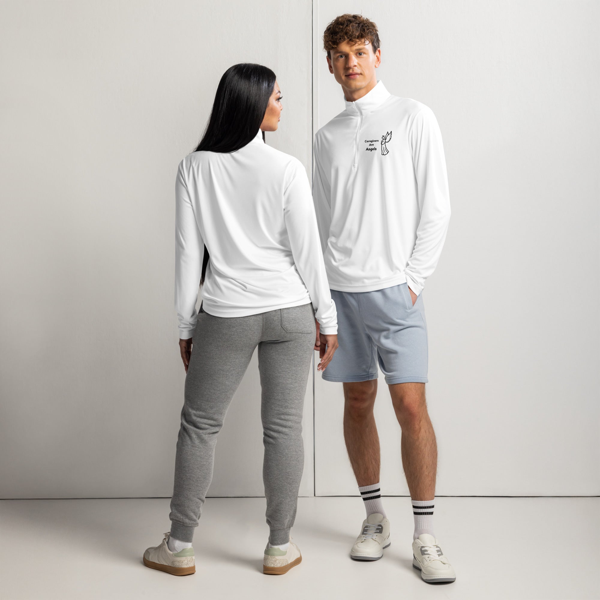 Two individuals wearing white lightweight quarter-zip pullovers with black graphics, showcasing a casual and relaxed setting.