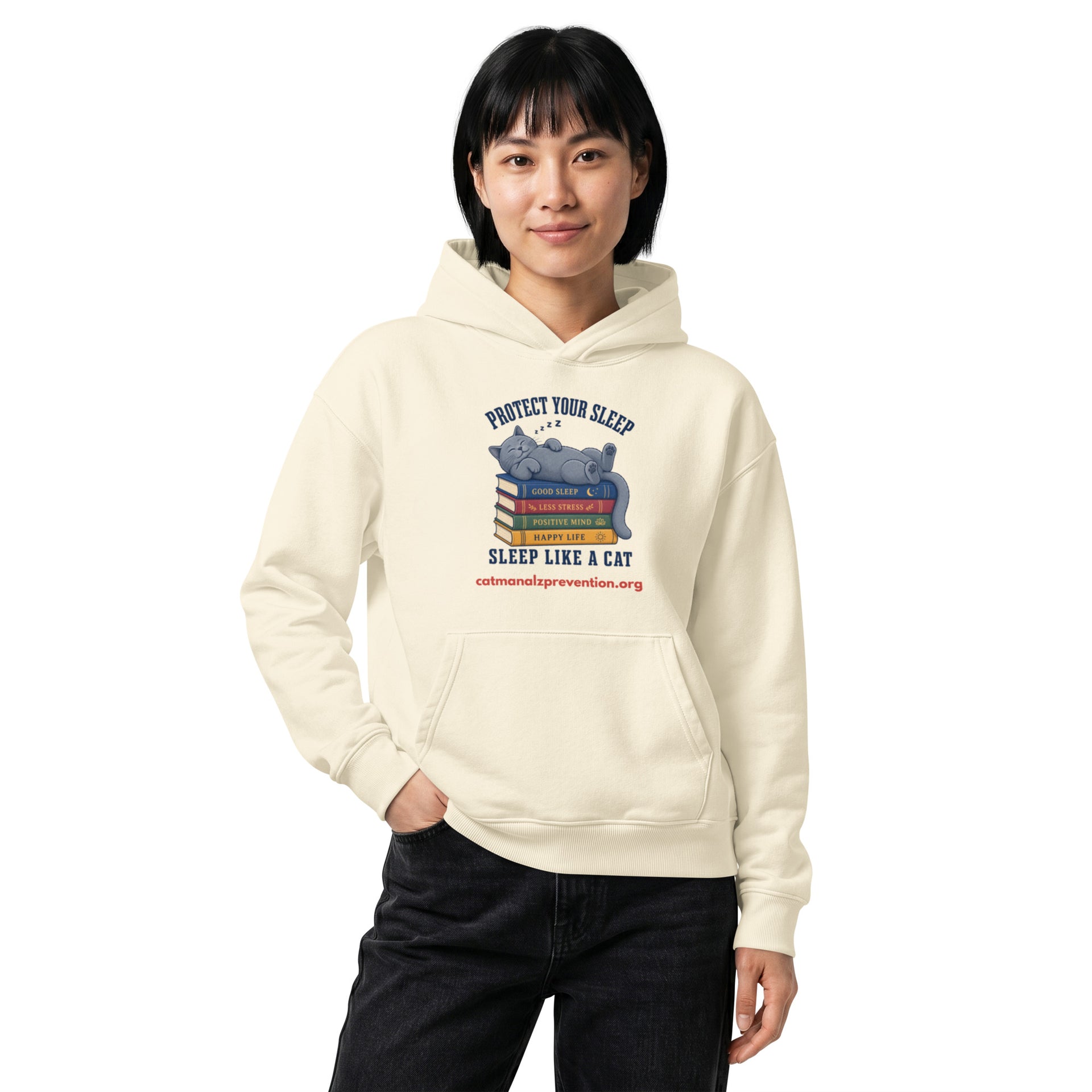 Person wearing a cream unisex relaxed mid-weight hooded sweatshirt with a cat sleeping on books graphic