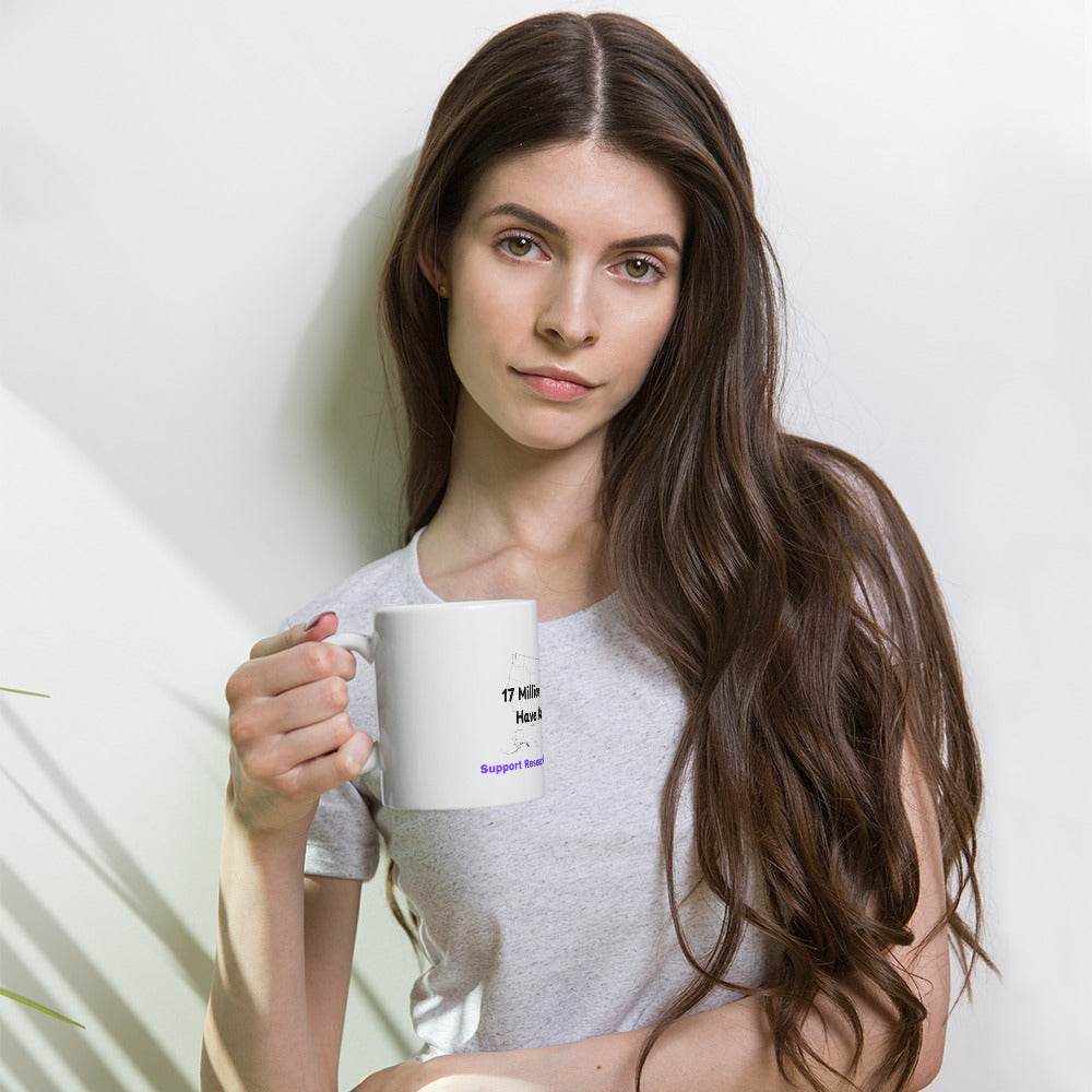 Woman holding a white glossy mug with Alzheimer awareness text
